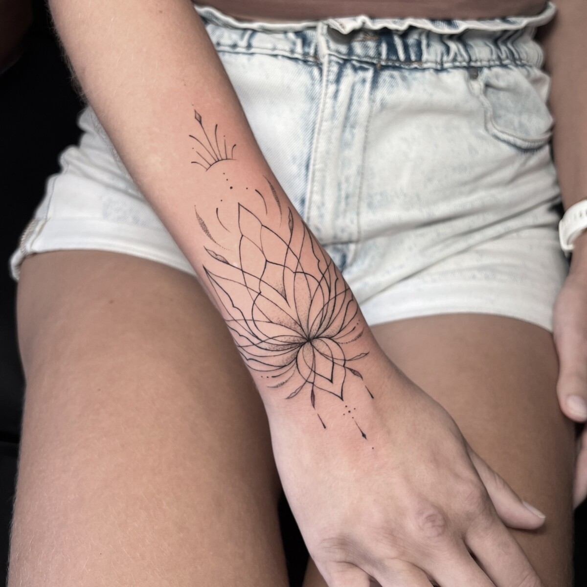 delicate flower tattoo on a forearm